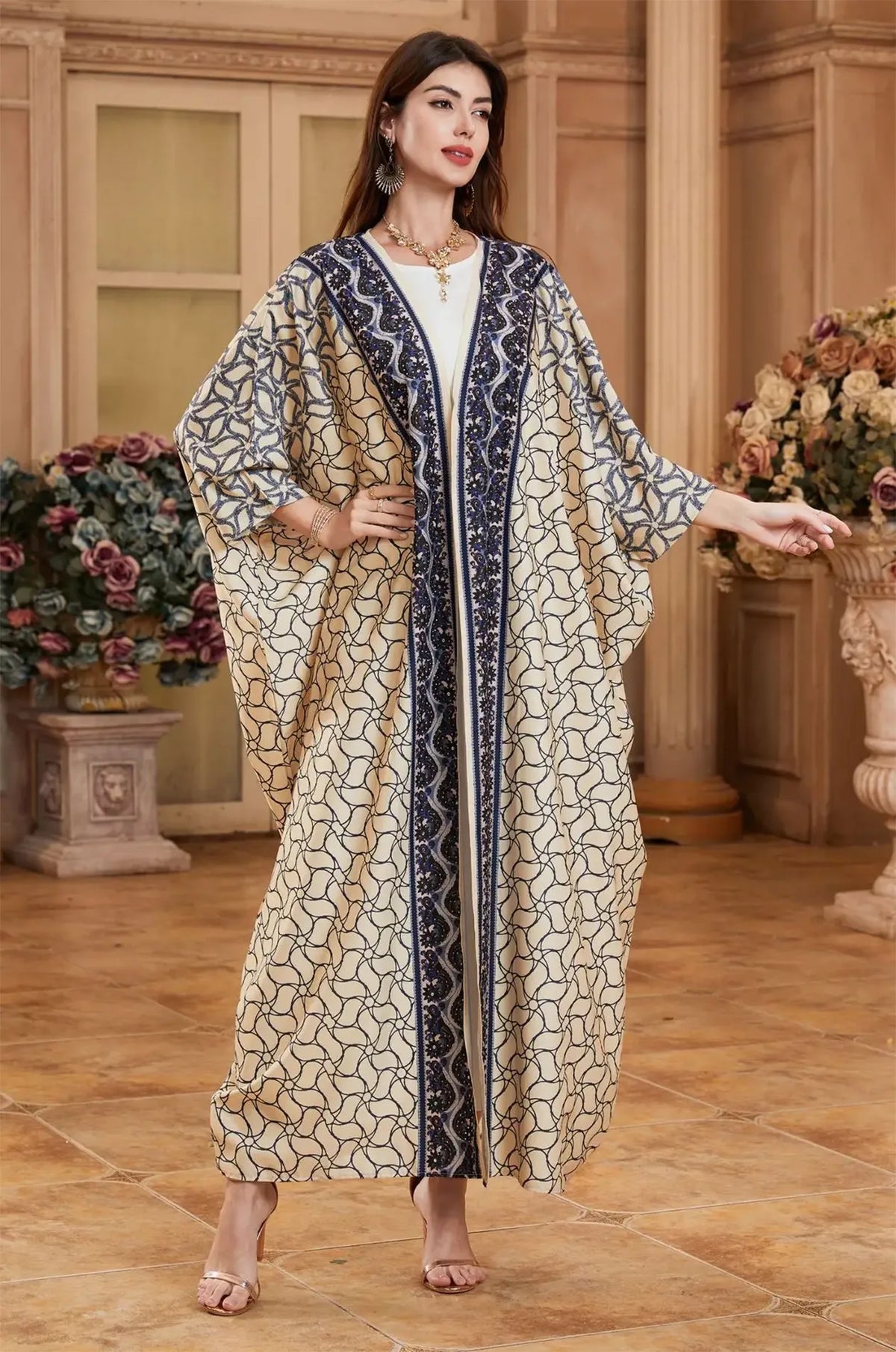 Elegant model posing in the Zelia ivory kaftan with navy blue embroidery.