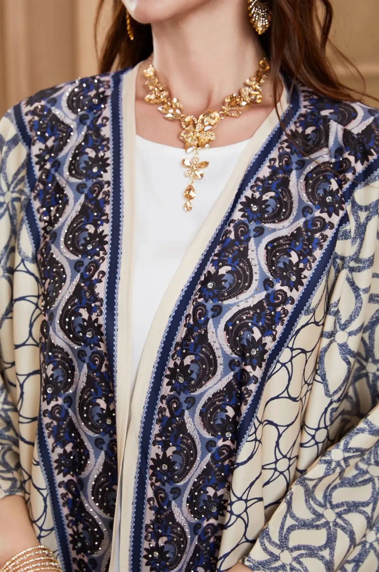 Extreme close-up of the navy blue embroidery and rhinestones on the Zelia kaftan.
