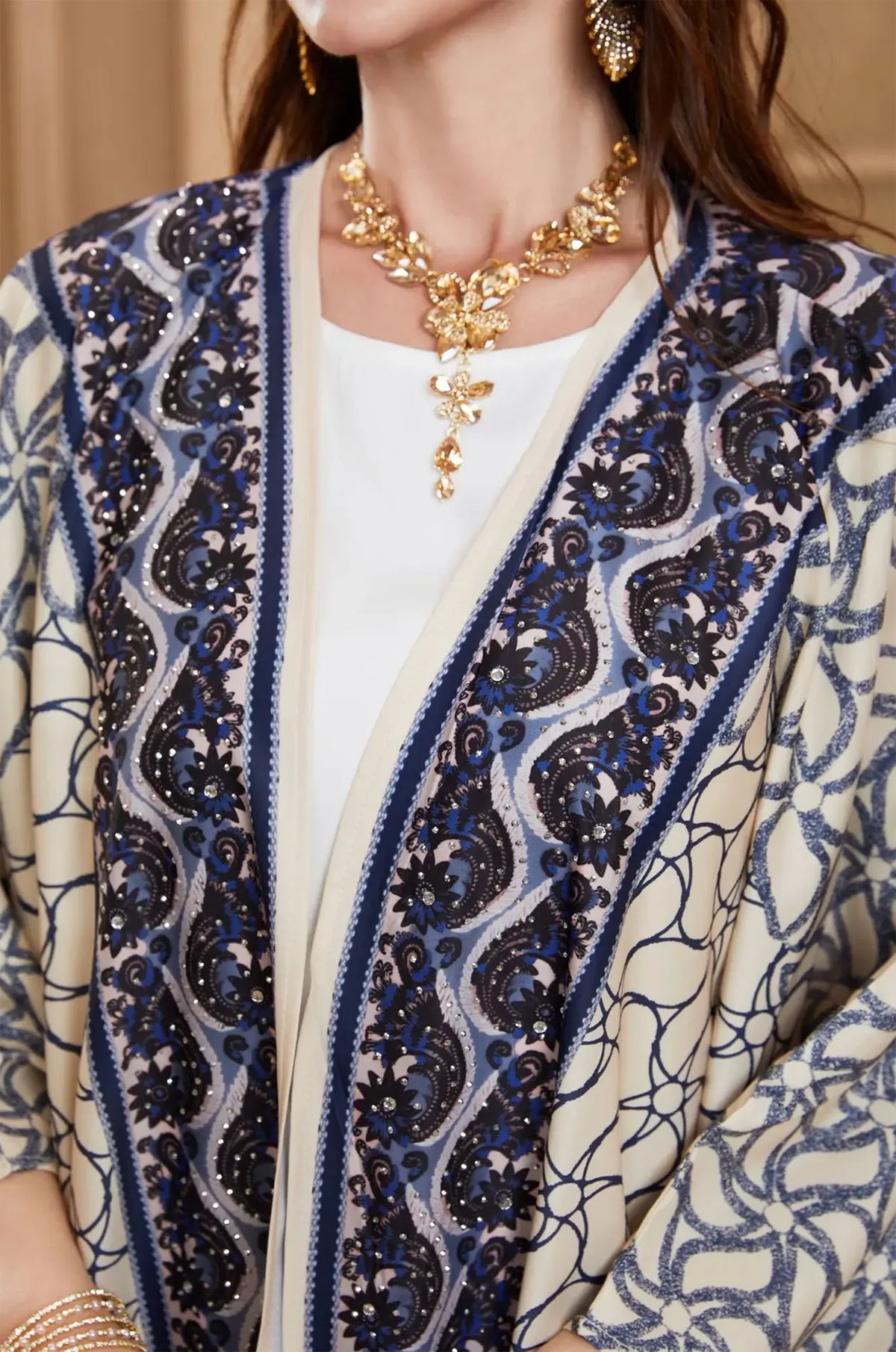 Extreme close-up of the navy blue embroidery and rhinestones on the Zelia kaftan.